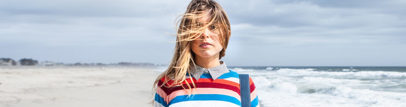 Closeup of Woman wearing a strip sweater at the beach in winter.