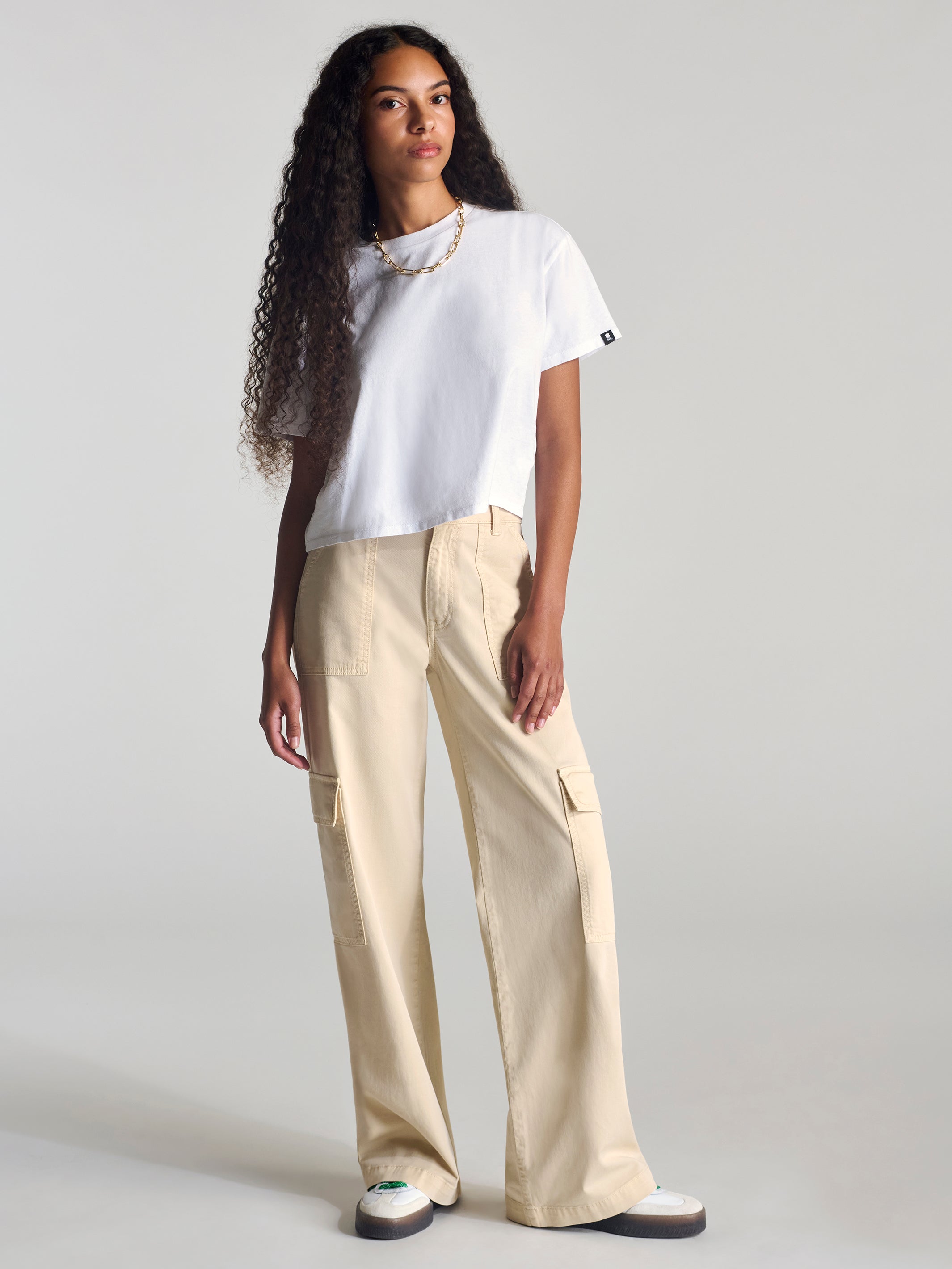 Boxy white cropped T-shirt ending above beige cargo trouser pockets